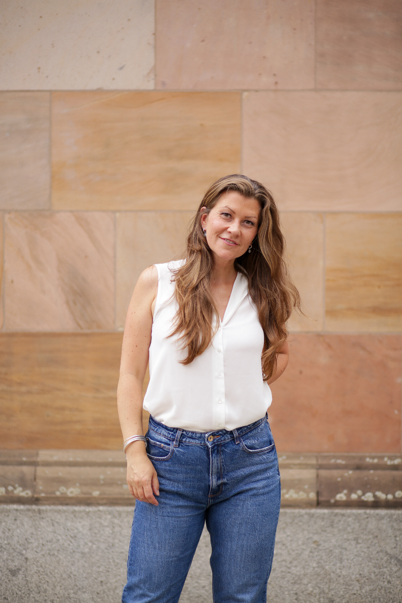 Julia Rosenwert in weißer Bluse vor Sandsteinwand